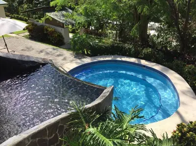a small swimming pool in a yard with a landscaping at Herradura Home 2 in Herradura