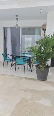 a patio with a table and chairs and a plant at Herradura Home 2 in Herradura