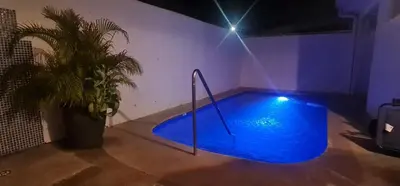 a blue swimming pool in a room with a plant at Herradura Home 2 in Herradura