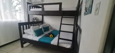 a black bunk bed with a flower on top of it at Herradura Home 2 in Herradura