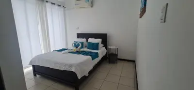 a bedroom with a bed with blue pillows at Herradura Home 2 in Herradura