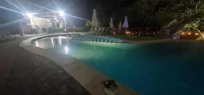 an empty swimming pool at night with lights at Herradura Home 2 in Herradura