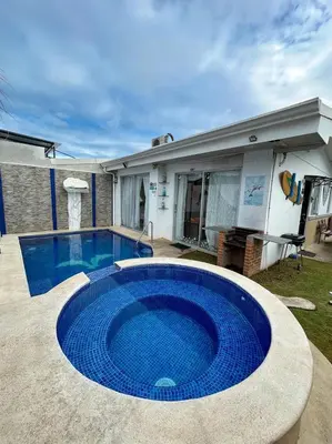 a large blue swimming pool in front of a house at Herradura Home in Herradura