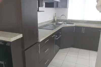 a kitchen with gray cabinets and a sink at Herradura Home in Herradura
