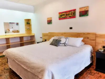 a bedroom with a large white bed and a window at 714 Studios in San José