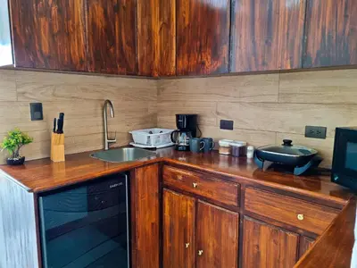 a kitchen with wooden cabinets and a counter top with a sink at 714 Studios in San José