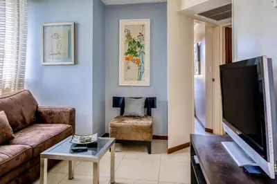 a living room with a couch and a flat screen tv at Costa Linda 2-28 in Jacó