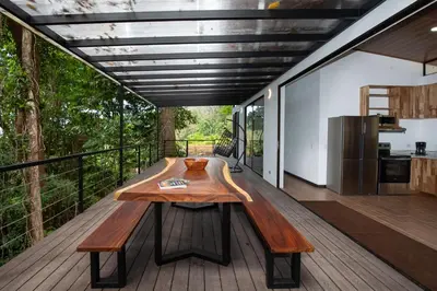 a wooden table on the deck of a house at Casa Henaway - Portasol Vacation in Savegre