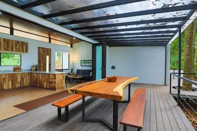 a living room with a wooden table and a couch at Casa Henaway - Portasol Vacation in Savegre