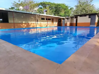 a pool with blue water in front of a building at Hotel El Cocobolo Food&Rest Room 1 B&B WiFi AC Pkg Free Swimmingpool in Ahogados