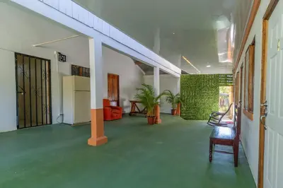 a room with a green floor and a hallway with a chair at Hotel El Cocobolo Food&Rest Room 1 B&B WiFi AC Pkg Free Swimmingpool in Ahogados