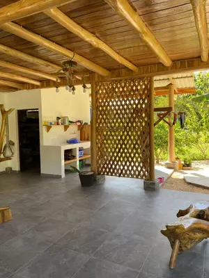 a living room with a wooden ceiling and a stone floor at Casa Gratitud in Paquera