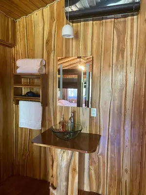 a bathroom with a sink in a wooden wall at Casa Gratitud in Paquera