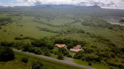 an aerial view of a house in a field with a road at Hotel El Cocobolo Food&Rest Room 7 B&B WiFi AC Pkg Free Swimmingpool in Ahogados