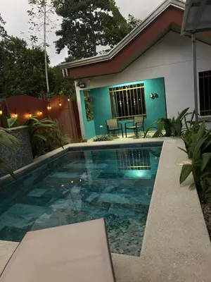 a swimming pool in front of a house at Villa JADE, La Fortuna Downtown in Fortuna