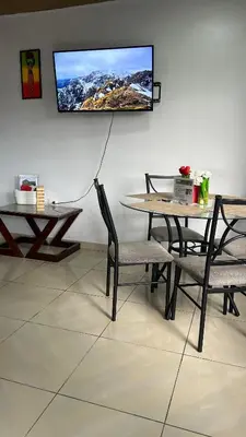 a dining room with two tables and a tv on the wall at Villa JADE, La Fortuna Downtown in Fortuna