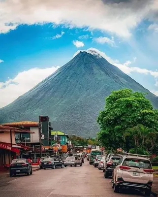 a mountain with a bunch of cars parked on a street at Villa JADE, La Fortuna Downtown in Fortuna