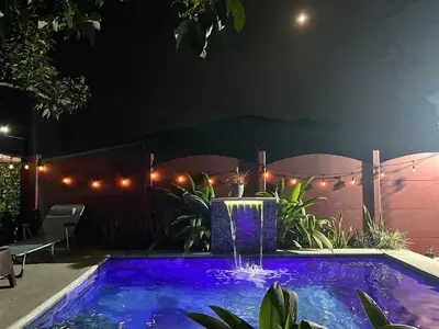 a swimming pool at night with purple lights at Villa JADE, La Fortuna Downtown in Fortuna