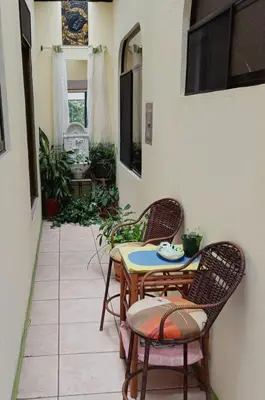 a patio with two chairs and a table and a table at Nirvana Apartament Hostal in Alajuela City