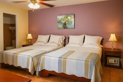 two beds sitting next to each other in a bedroom at Hotel Puerta del Sol - San Jose Airport in San José