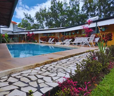 a swimming pool with a table and chairs next to a building at Hotel Puerta del Sol - San Jose Airport in San José