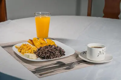 a plate of food and a cup of orange juice at Hotel El Cocobolo Food&Rest Room 2 B&B WiFi AC Pkg Free Swimmingpool in Ahogados