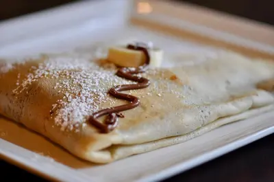 a stack of pancakes with powdered sugar on a plate at Chillout House in Monteverde Costa Rica