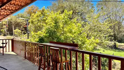 a deck with two chairs and a tree at Chillout House in Monteverde Costa Rica
