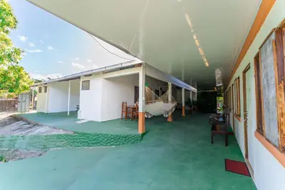a house with a green floor and a boat on it at Hotel El Cocobolo Food&Rest Room 3 B&B WiFi AC Pkg Free Swimmingpool in Liberia