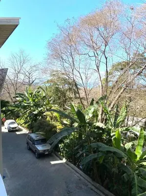 a car parked in a parking lot next to trees at BoHo Home in Gated Eco Residence marAmar - Top location in Santa Teresa Beach