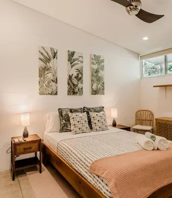 a bedroom with a bed and two paintings on the wall at BoHo Home in Gated Eco Residence marAmar - Top location in Santa Teresa Beach