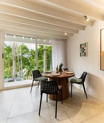 a dining room with a table and chairs and a window at BoHo Home in Gated Eco Residence marAmar - Top location in Santa Teresa Beach