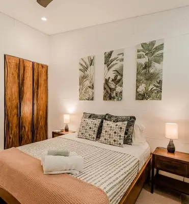 a bedroom with a bed and two paintings on the wall at BoHo Home in Gated Eco Residence marAmar - Top location in Santa Teresa Beach