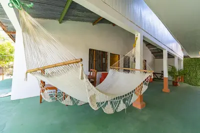 a room with two hammocks on a house at Hotel El Cocobolo Food&Rest Room 4 B&B WiFi AC Pkg Free Swimmingpool in Liberia