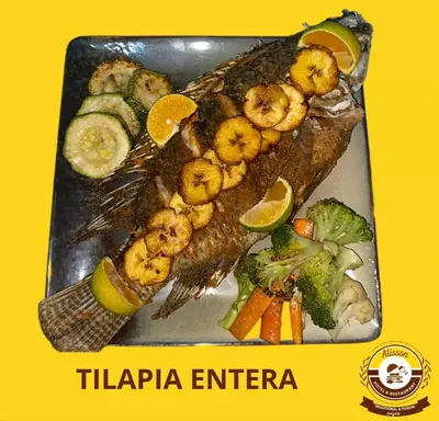 a plate of fish with shrimp and vegetables on it at Alisson Hotel y Restaurant in Monteverde Costa Rica