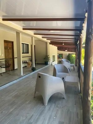 a patio with white chairs and tables on a wooden floor at Natüra Hotel Monteverde in Monteverde Costa Rica