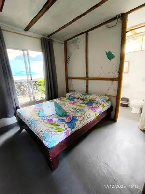 a small bed in a room with a window at Flor de bambú in Uvita