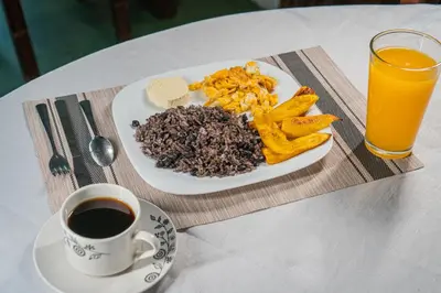 a plate of food and a cup of coffee on a table at Hotel El Cocobolo Food&Rest Room 6 B&B WiFi AC Pkg Free Swimmingpool in Liberia