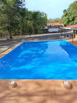 a large blue swimming pool with trees in the background at Hotel El Cocobolo Food&Rest Room 6 B&B WiFi AC Pkg Free Swimmingpool in Liberia