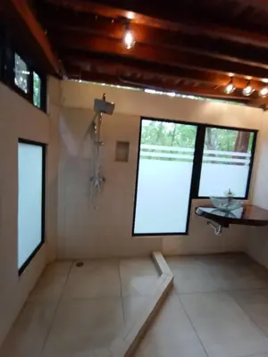 a bathroom with a shower in a room at PachaMama Bio Hostel in Tamarindo