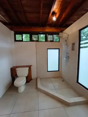 a bathroom with a toilet and a shower at PachaMama Bio Hostel in Tamarindo