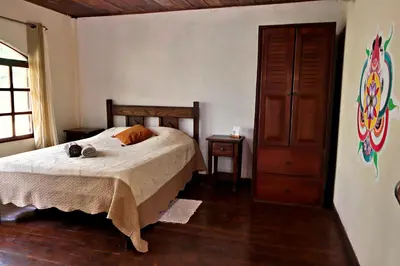 a bedroom with a bed and a dresser at PachaMama Bio Hostel in Tamarindo