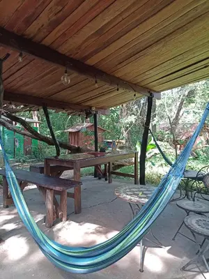 a hammock in a pavilion with tables and benches at PachaMama Bio Hostel in Tamarindo