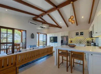 an open kitchen with white cabinets and a large island at Plaza Mercado 24 At Las Catalinas in Playa Danta