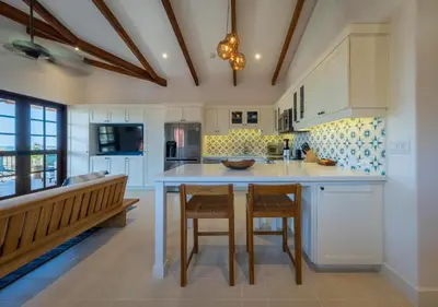 a kitchen with white cabinets and a table and chairs at Plaza Mercado 24 At Las Catalinas in Playa Danta