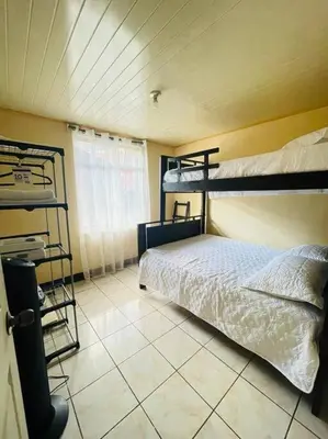 a bedroom with two bunk beds and a tiled floor at A 5 minutos del aeropuerto in Alajuela City