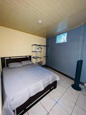 a bedroom with a large bed and a window at A 5 minutos del aeropuerto in Alajuela City