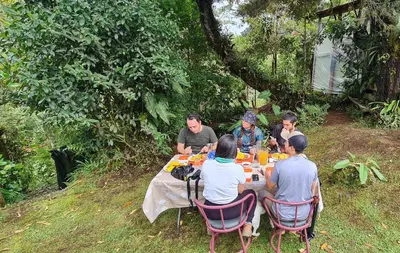 a group of people sitting at a table eating at Reserva y Estancia Robles Mimosos Lodge in Cartago