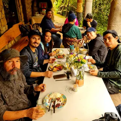 a group of people sitting at a table eating food at Reserva y Estancia Robles Mimosos Lodge in Cartago
