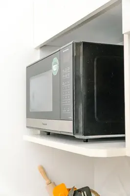 a microwave oven on a shelf in a kitchen at Casa Lapa Roja in Playa Hermosa